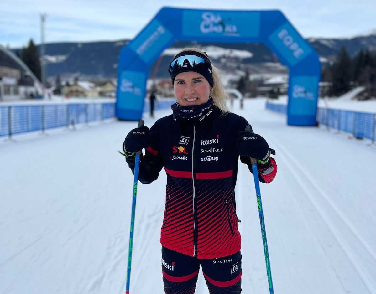 Maastohiiht&auml;j&auml; Oona Kettunen hymyilee hiihtoladulla sauvat k&auml;dess&auml;, p&auml;&auml;ll&auml;&auml;n hiihtoasu.