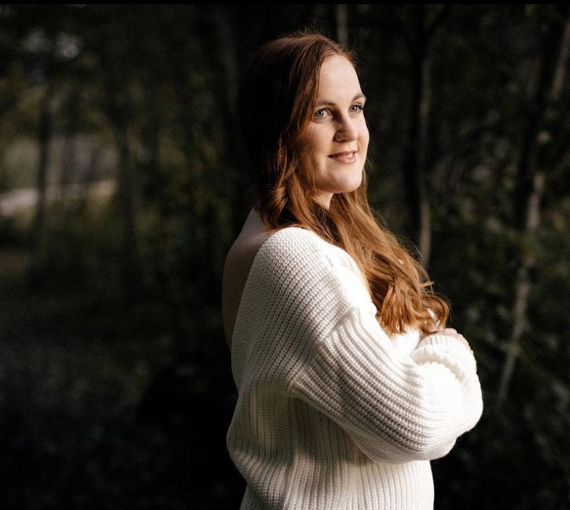 Hymyilev&auml; Jutta poseeraa k&auml;det puuskassa