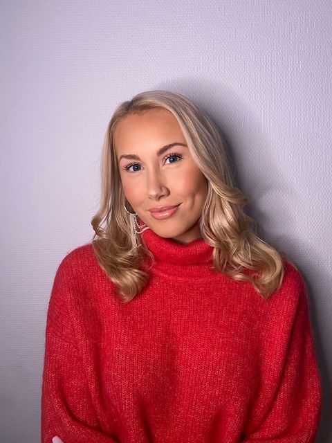 Viveka hymyilee puolikuvassa p&auml;&auml;ll&auml;&auml;n l&auml;mpim&auml;n oloinen neule
